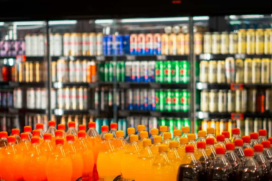 Colorful bottled and canned drinks in convenience store aisle