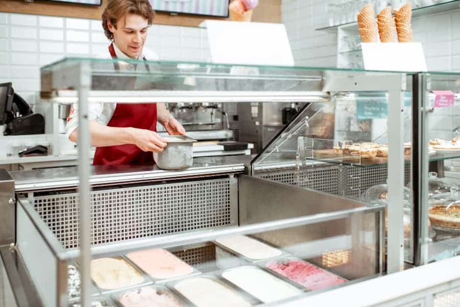Worker putting ice cream into a refrigerator