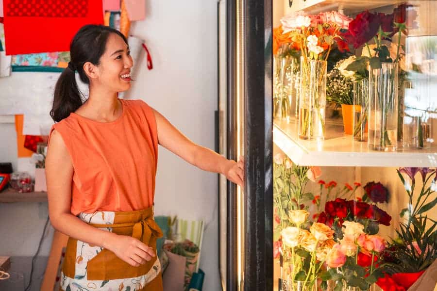 Florist taking out botanicals from floral cooler