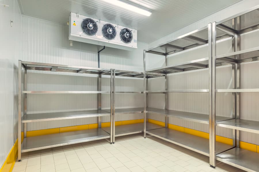 Warehouse walk-in freezer with empty metal shelves