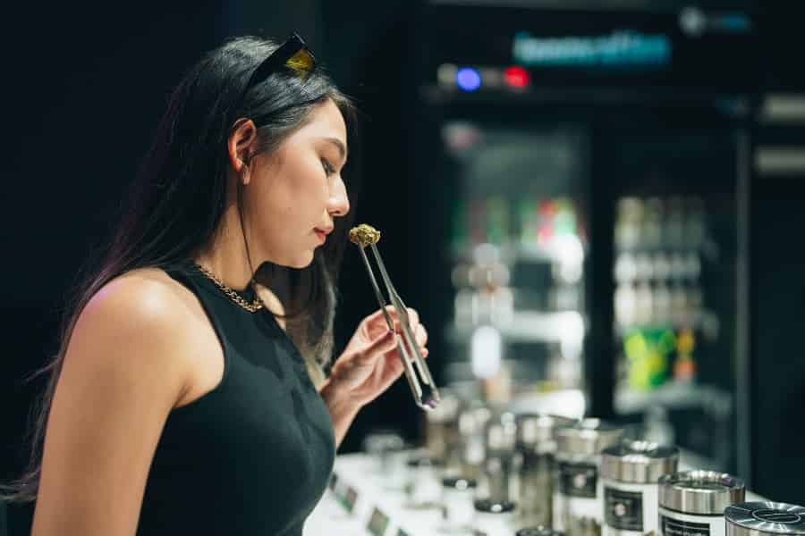 Person sniffing cannabis with cooler in background