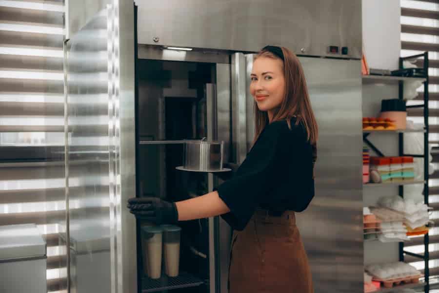 Professional baker putting dough in large cooler